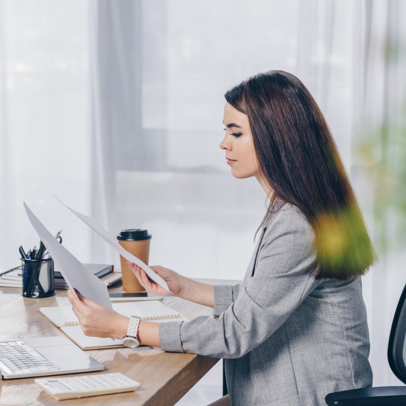 selective-focus-of-recruiter-holding-papers-at-table-in-office.jpg